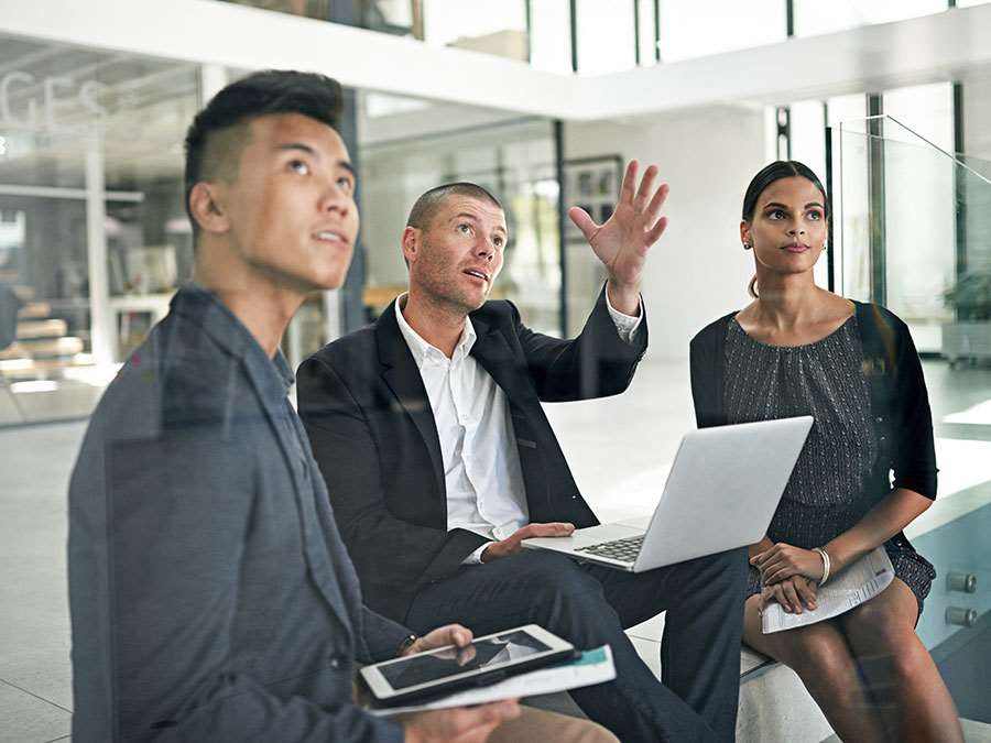 A few people in business attire look off camera while in a collaborative discussion.