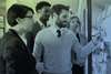 Man with group around him at whiteboard with sticky notes