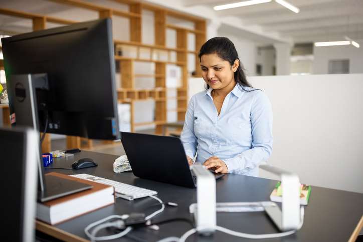 Woman in corporate setting at laptop computer