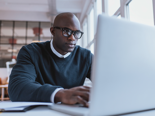 Man in glasses e-learning on his computer